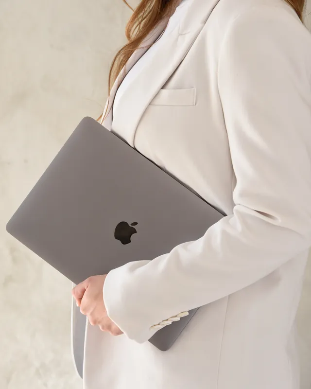 Laptop egy fehér blézeres kar alatt